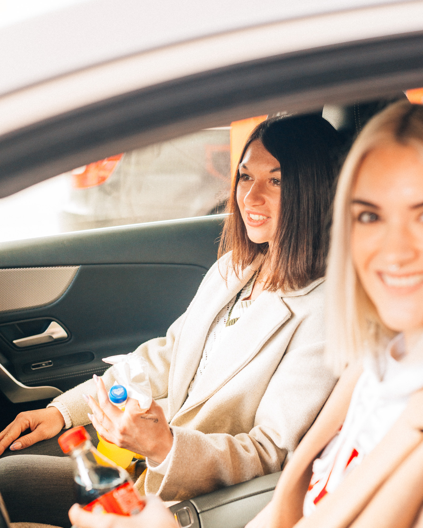 Pärchen sitzt mit Snacks im Auto und ist bereit für die Weiterfahrt.