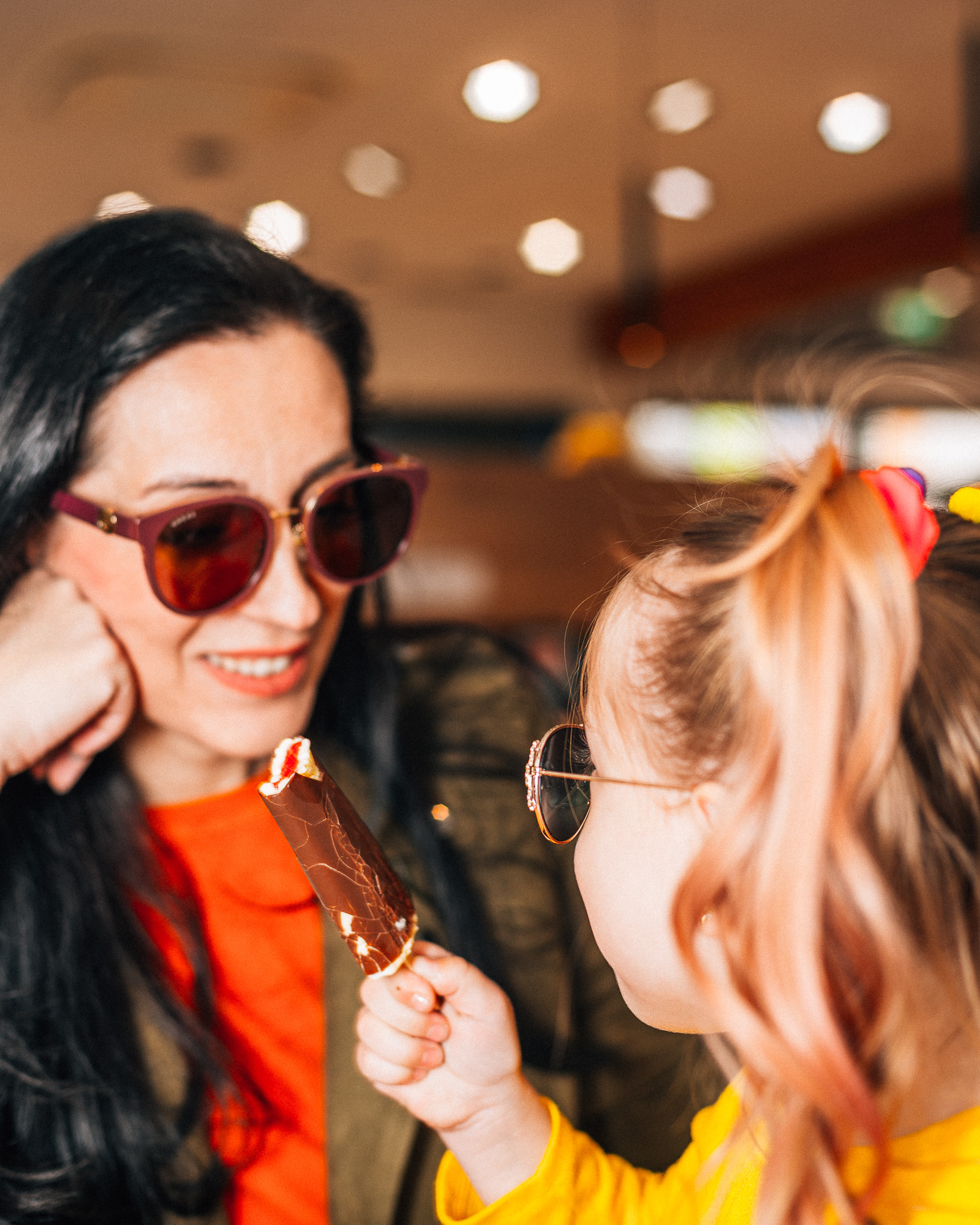 Mutter mit Kind sitzt im Cafe beim Treibstoffparadies und isst ein Eis.